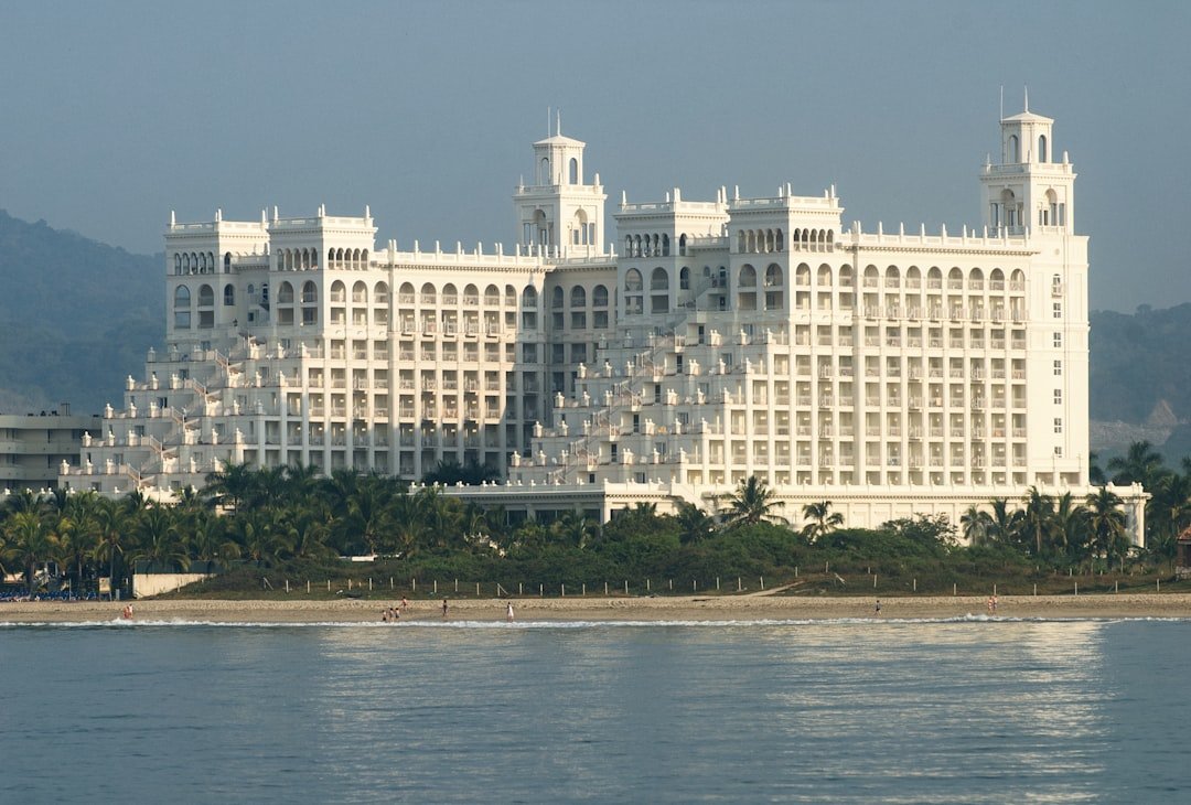 A majestic, white hotel sits on the beach.