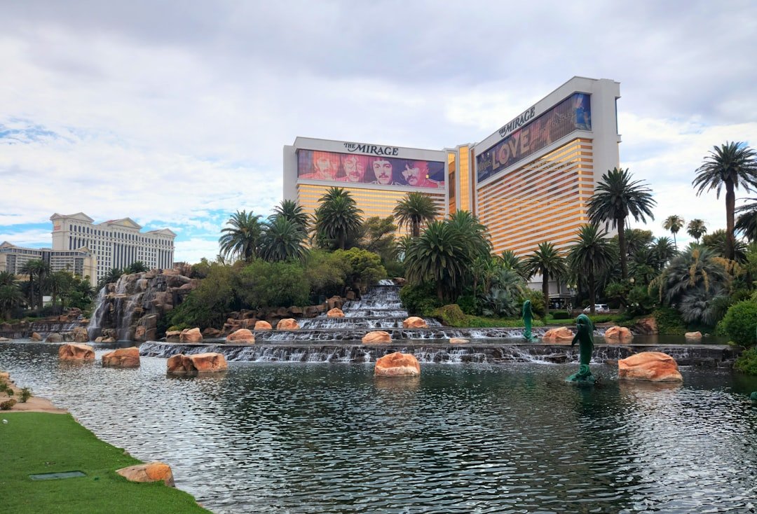 A view of a water park with a waterfall and a hotel in the background